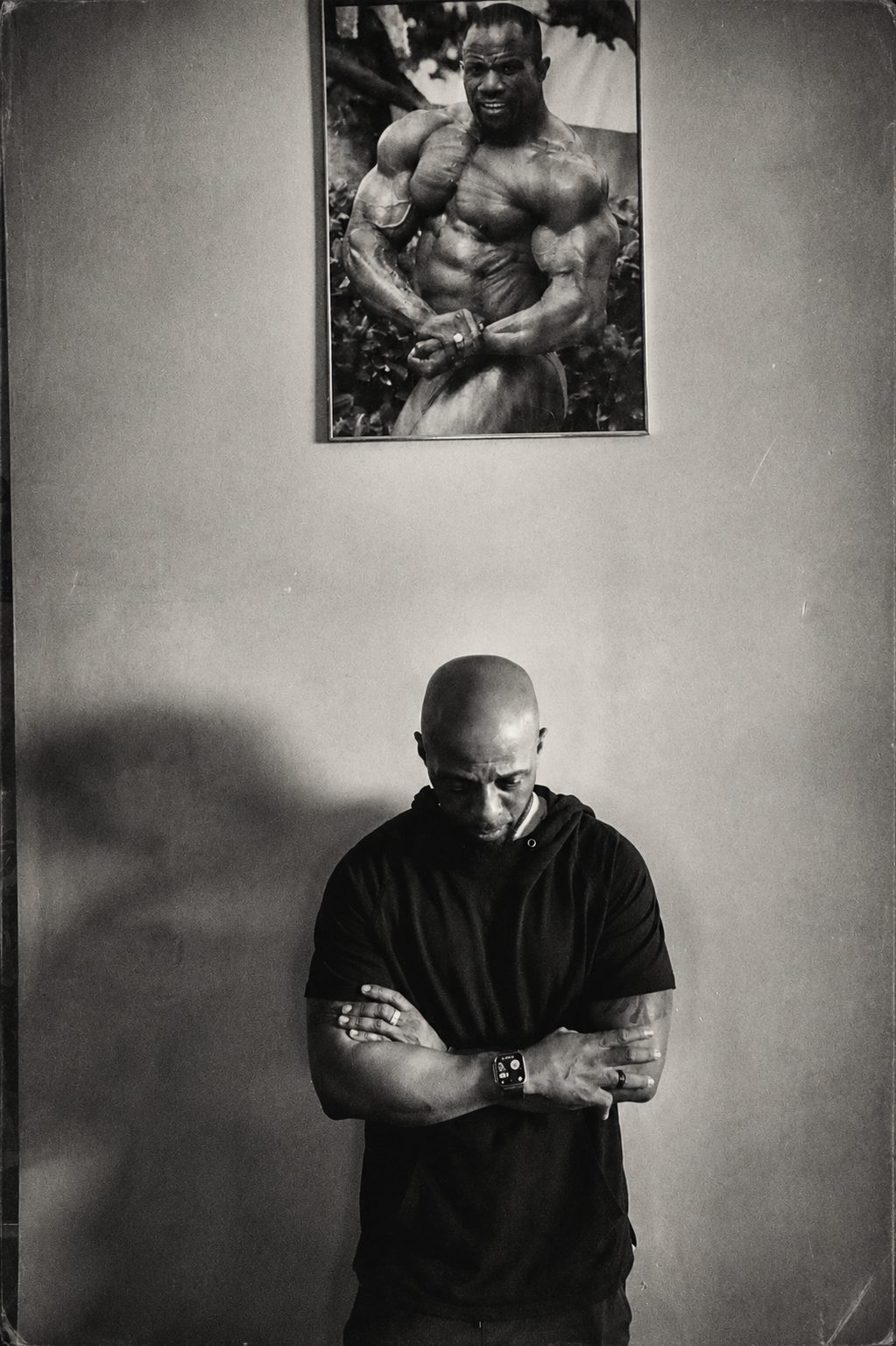 Athlete beneath a bodybuilder poster — fitness photography