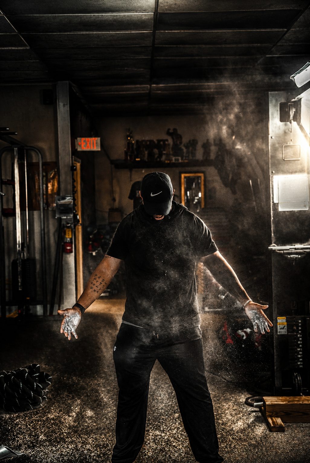 Athlete clapping chalk in a dark gym — fitness facility photography