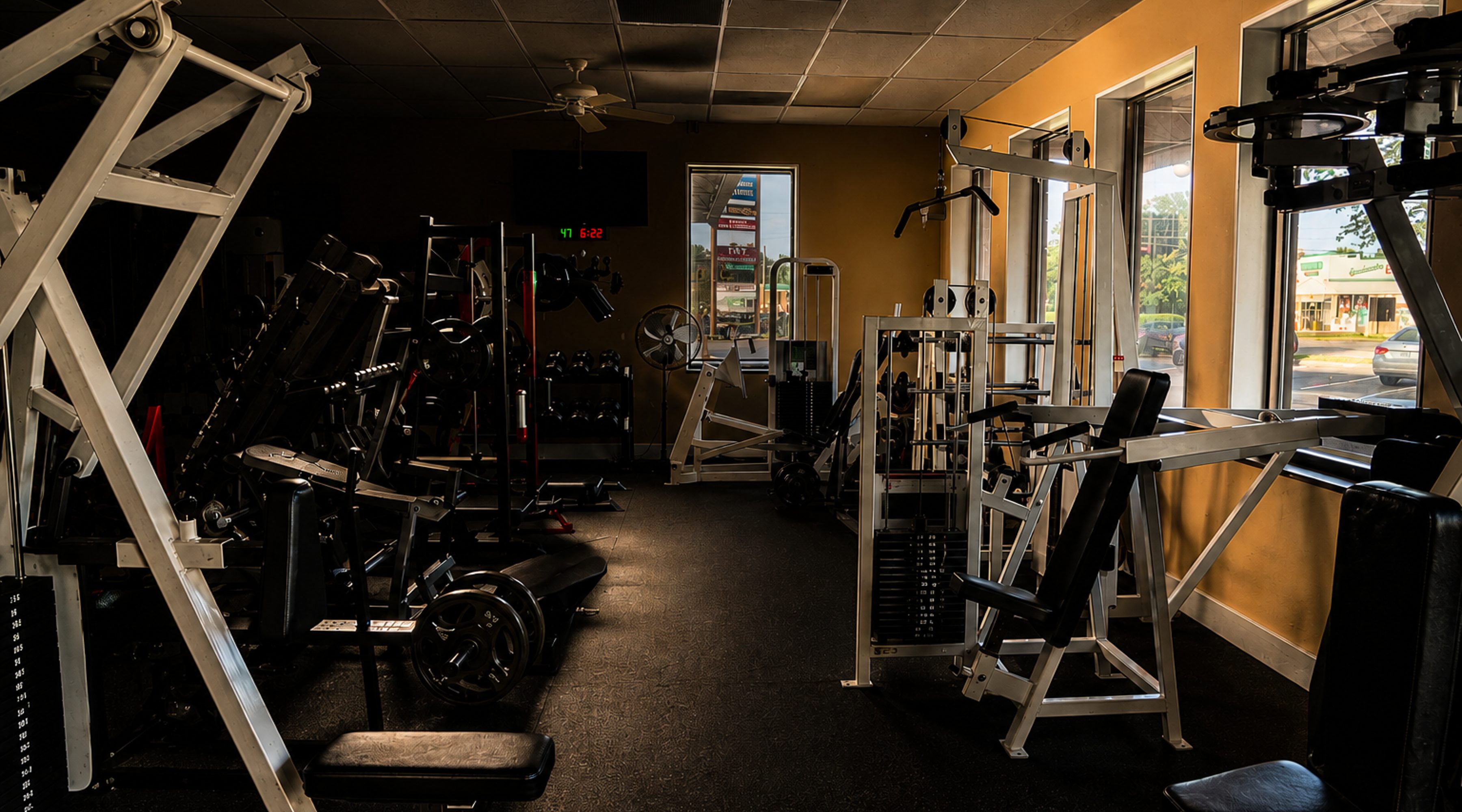 Resistance machines lined along the floor, gym interior photography