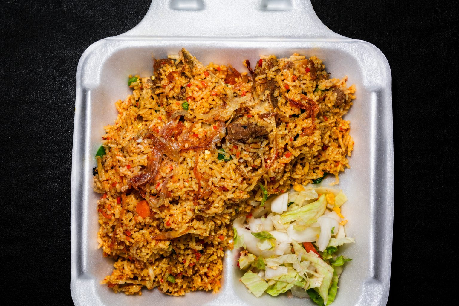 Layered biryani with rice and meat — food photography