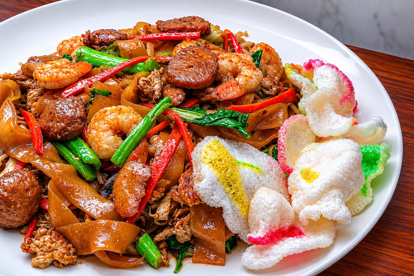 Char kway teow, wok-fried flat rice noodles with shrimp and prawn crackers — Indonesian restaurant food photography