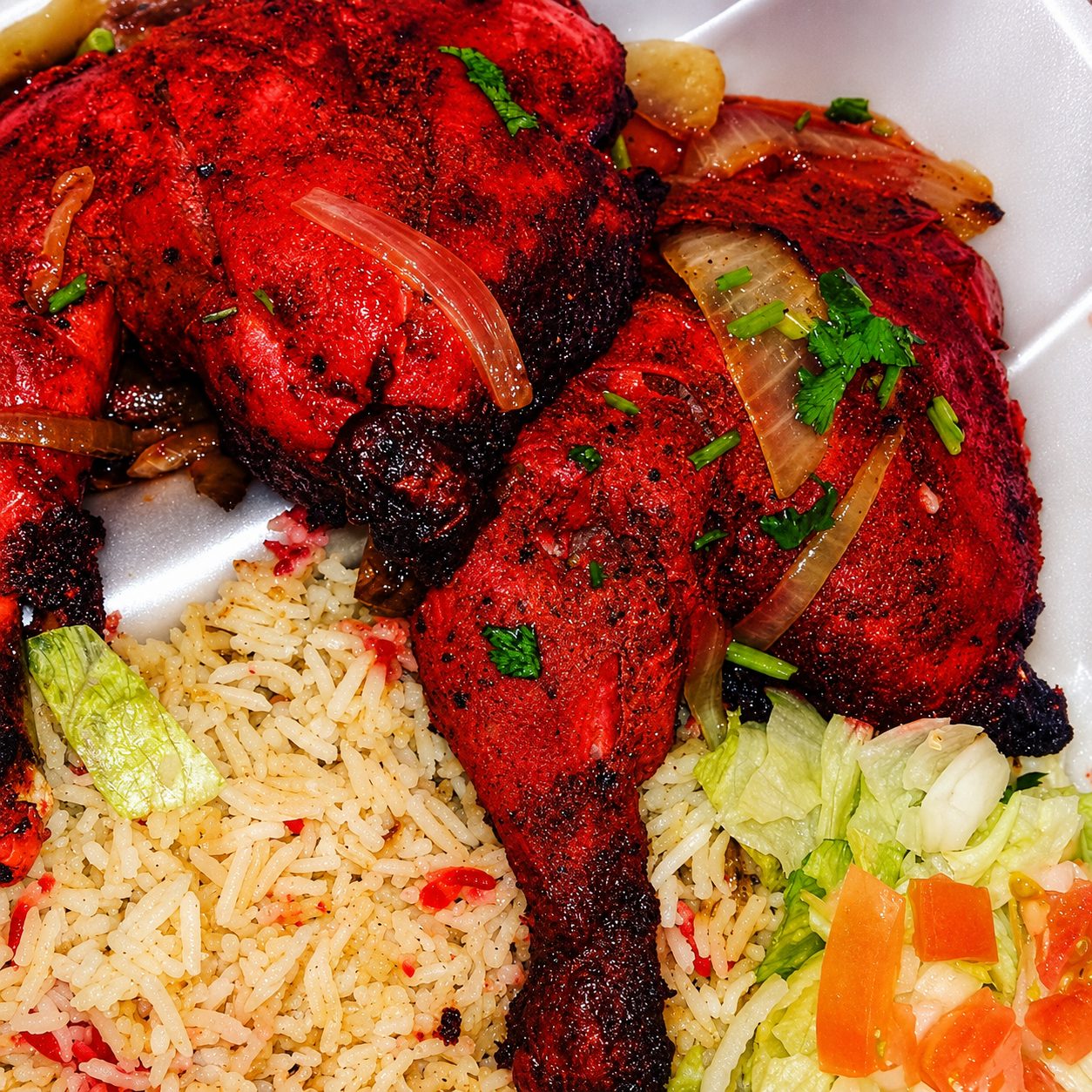 Tandoori chicken plated with garnish — food photography